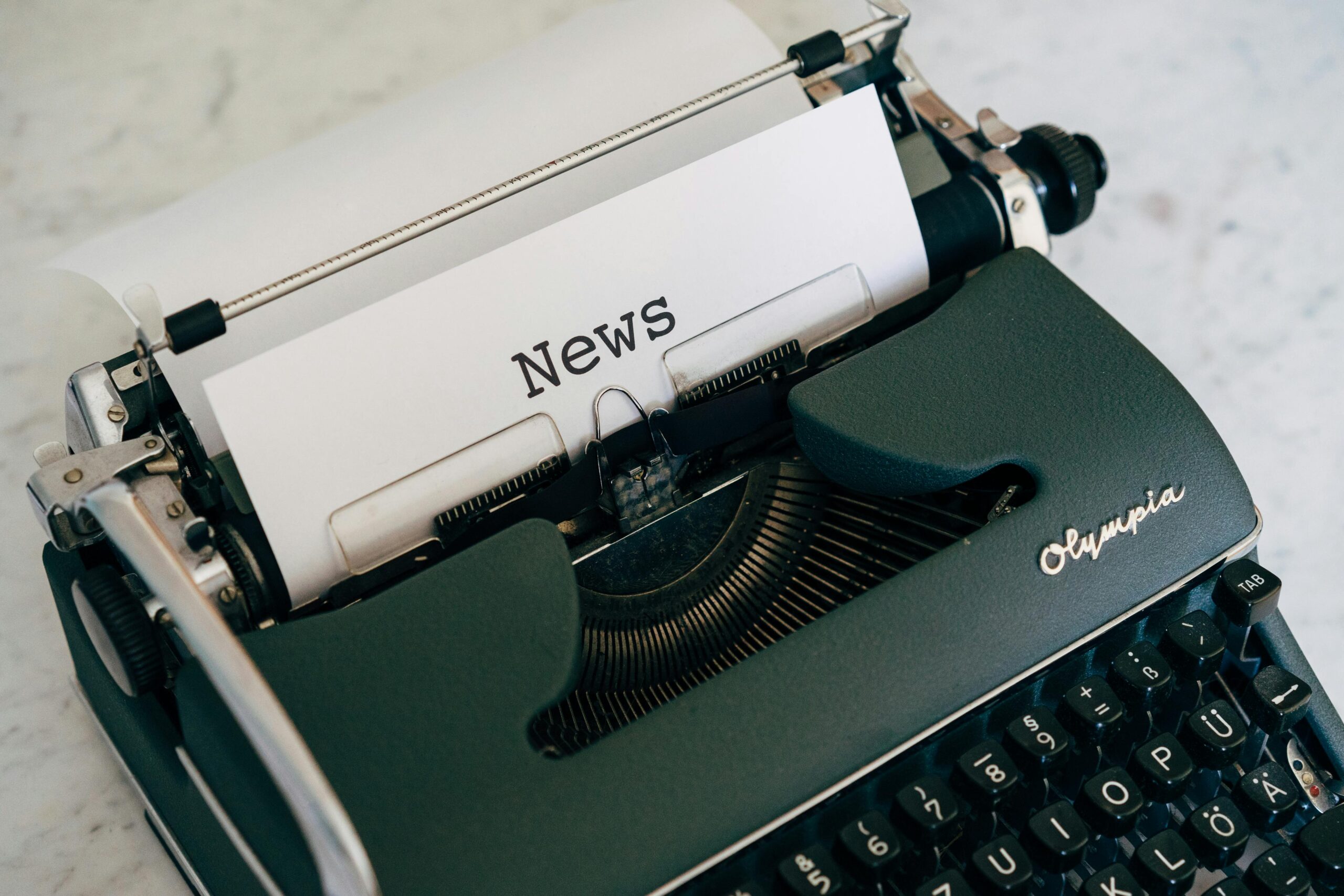 Vintage typewriter with the word “News” typed on a sheet of paper, representing media relations, journalism, and strategic communications.